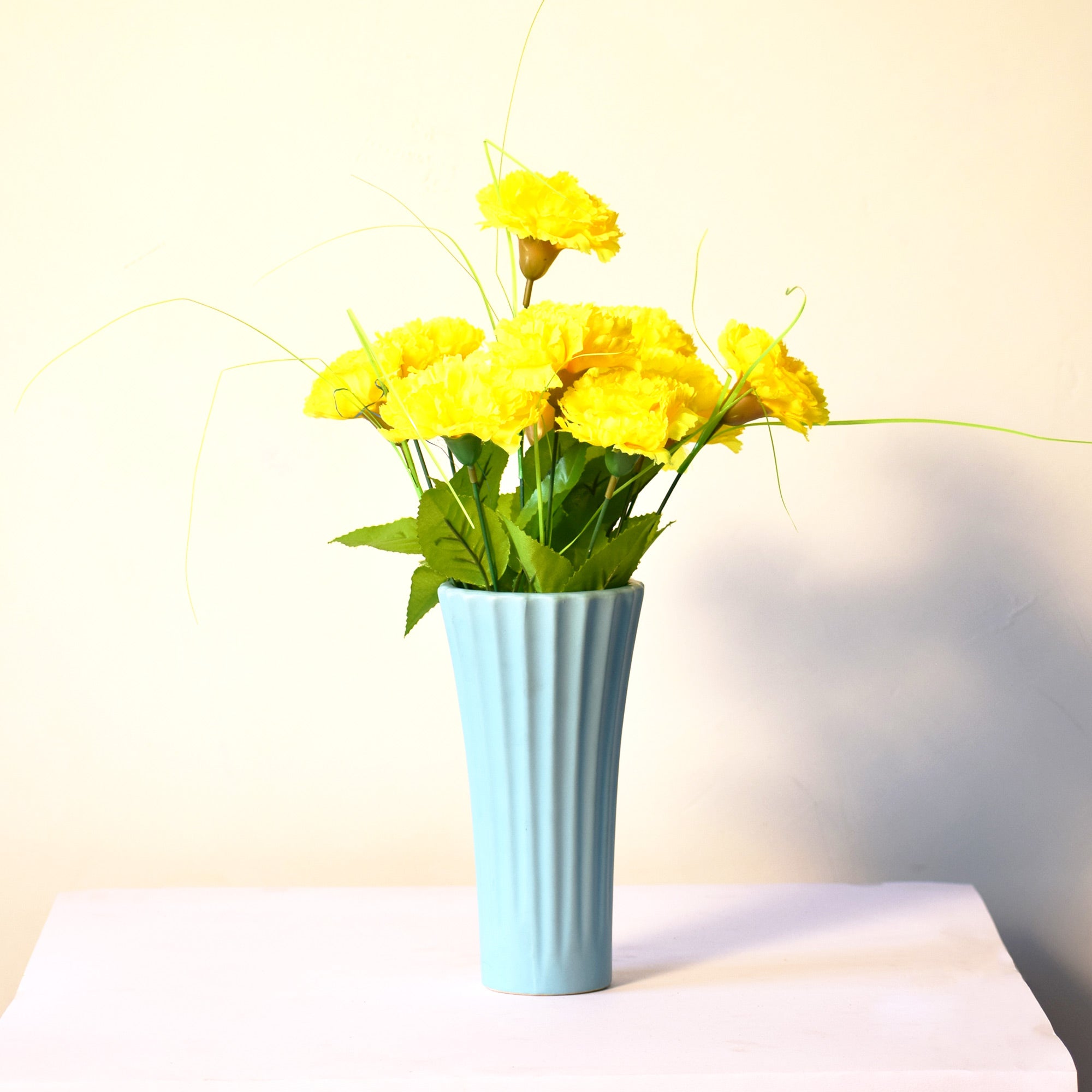 Sky blue ribbed ceramic flower vase with yellow flowers for modern luxury home décor and contemporary interior styling in India