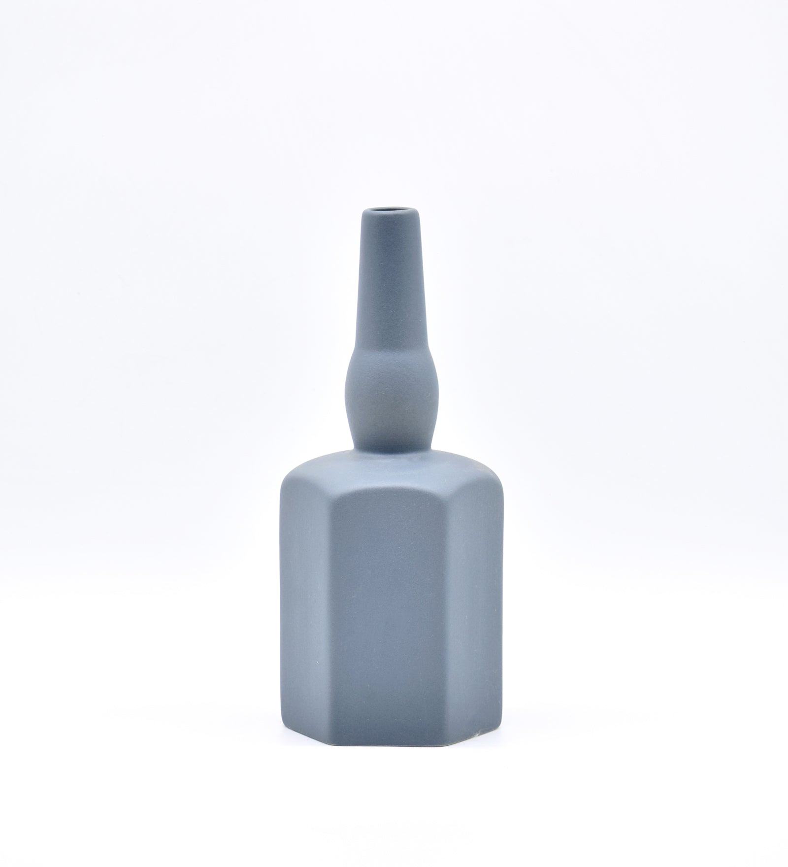 Luxury ceramic bottle-shaped vase with matte finish styled on a beige travertine console table in a modern Scandinavian-inspired interior with olive branches and minimalist décor.